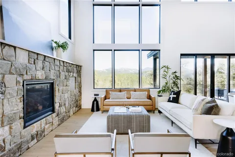 a living room with furniture large window and a fireplace