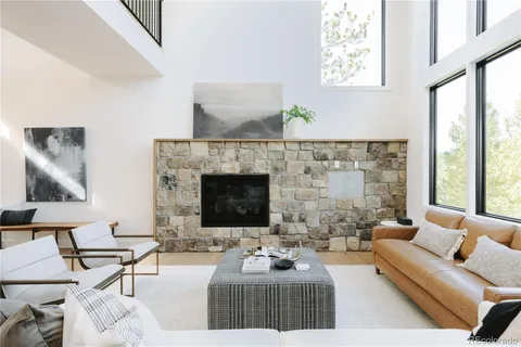 a living room with furniture a fireplace and a large window