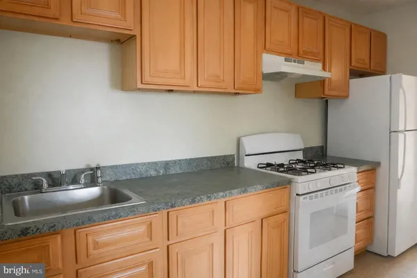 a kitchen with granite countertop a sink stove and refrigerator
