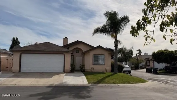 a front view of a house with a garden and trees