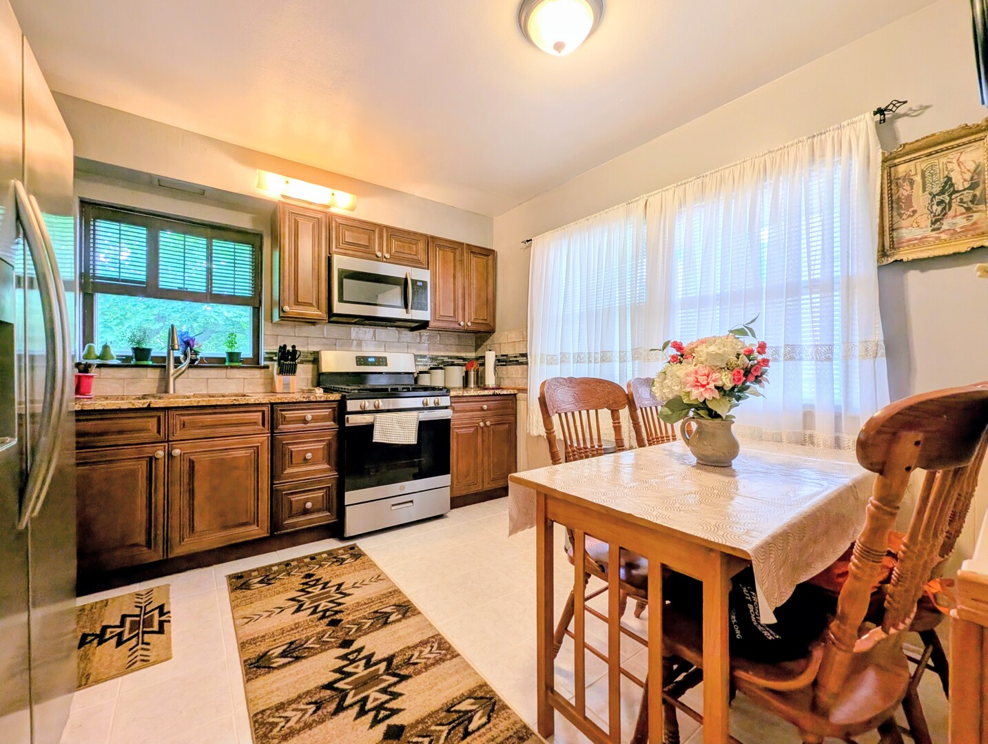 4229 North Keystone Avenue, Unit 3H Chicago, IL 60641 - Photo 9 of 22 a kitchen with stainless steel appliances kitchen island granite countertop a refrigerator a stove a microwave oven with a dining table and chairs