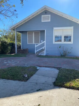 a front view of a house with a garden