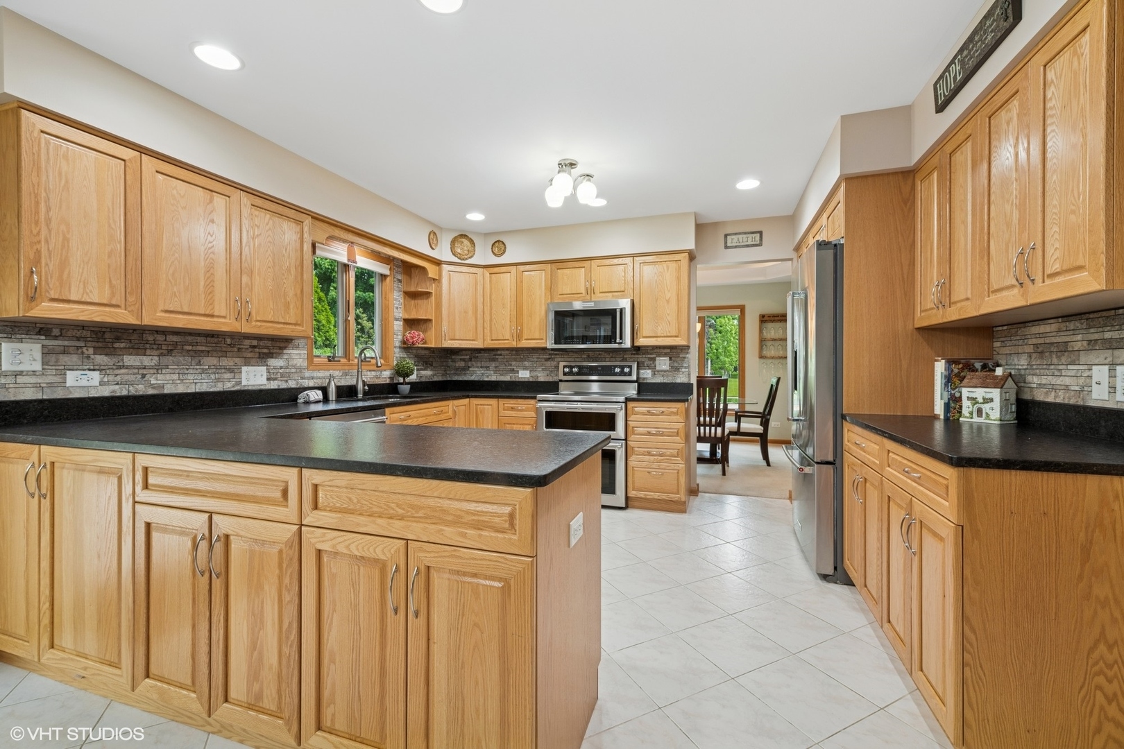 810 Tamarac Drive Algonquin, IL 60102 - Photo 6 of 36 a kitchen with stainless steel appliances granite countertop a stove sink microwave and cabinets
