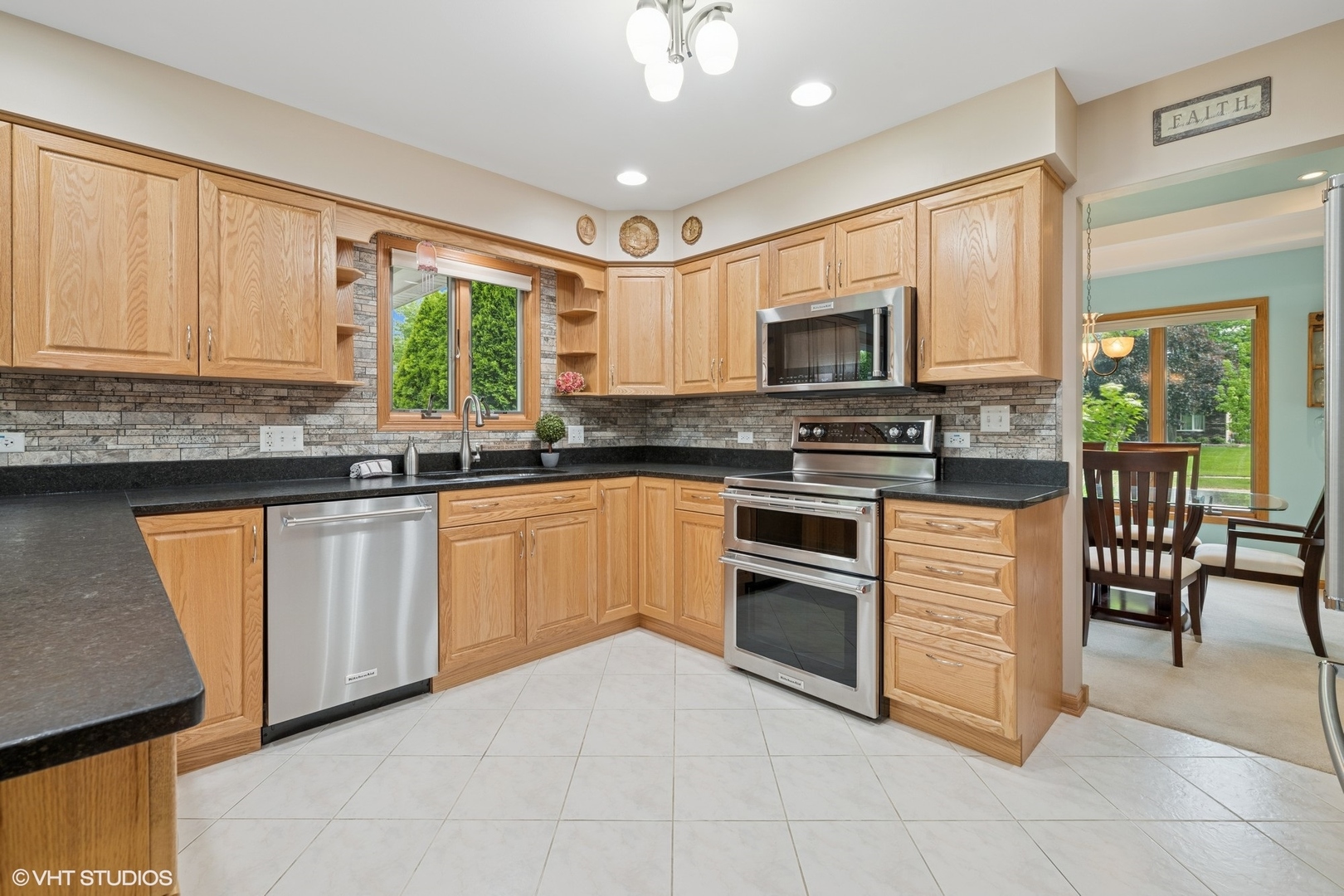 810 Tamarac Drive Algonquin, IL 60102 - Photo 7 of 36 a kitchen with stainless steel appliances granite countertop a stove top oven a sink dishwasher a dining table and chairs with wooden floor