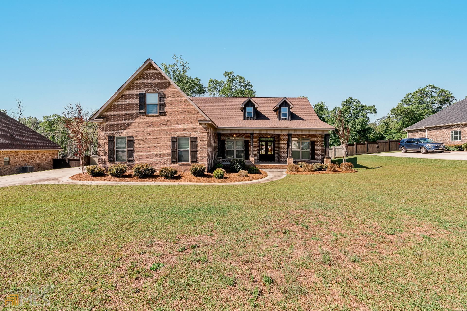 a front view of a house with swimming pool having outdoor seating