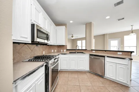 a kitchen with stainless steel appliances granite countertop a stove top oven microwave and cabinets