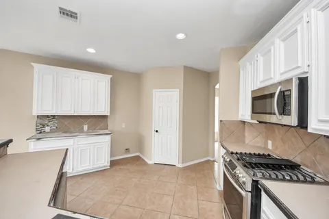 a kitchen with stainless steel appliances granite countertop a stove a sink and a microwave