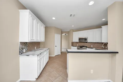 a kitchen with stainless steel appliances granite countertop a sink a stove and a refrigerator