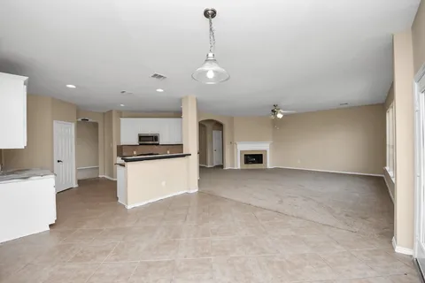 a view of kitchen with refrigerator and white cabinets