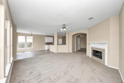 a view of an empty room with window and fire place