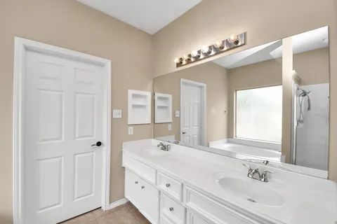 a bathroom with a double vanity sink a mirror and a
