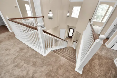 a view of staircase with railing and white walls