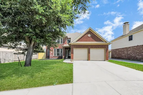 a front view of a house with a garden and trees