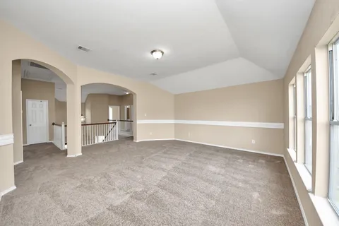 an empty room with entrance and windows