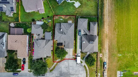 an aerial view of a house with a yard and large trees