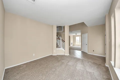 a view of empty room with wooden floor and window