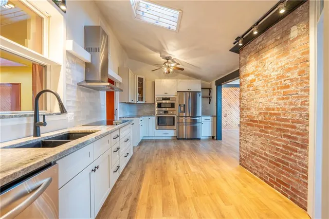 a large kitchen with cabinets and stainless steel appliances