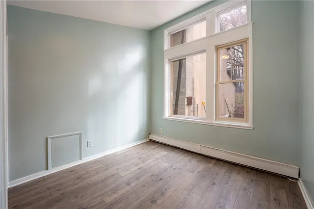 an empty room with wooden floor and a window