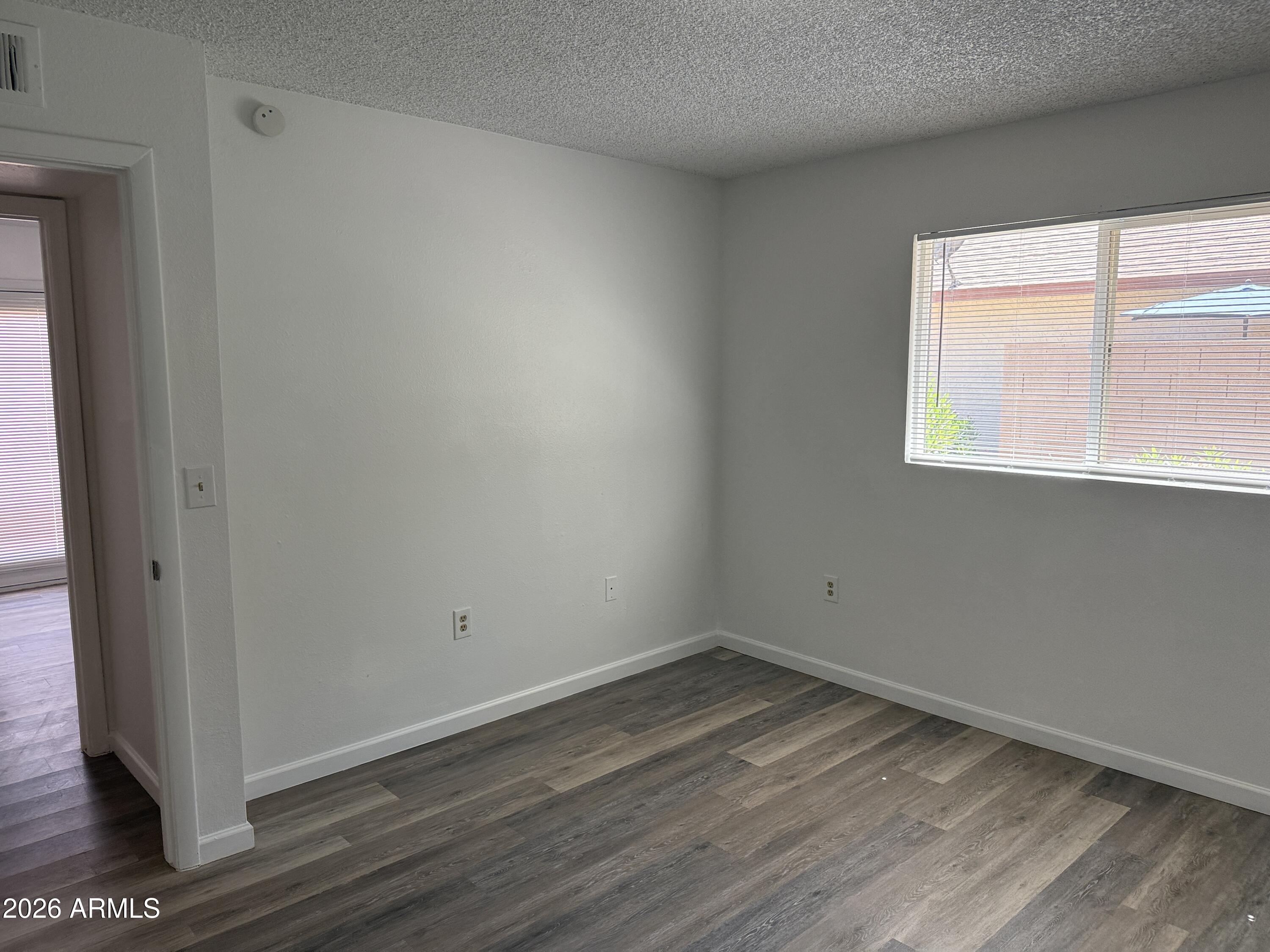 860 East Brown Road, Unit 53 Mesa, AZ 85203 - Photo 11 of 14 an empty room with wooden floor and windows