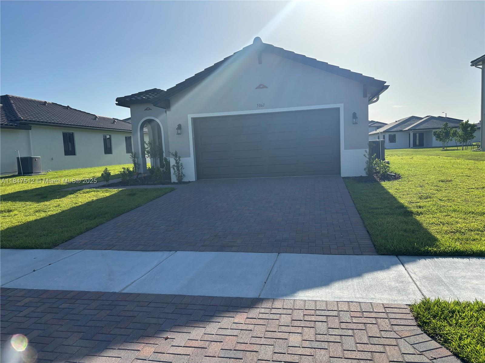 5061 Panella Avenue Immokalee, FL 34142 - Photo 13 of 13 a front view of a house with a yard and a garage