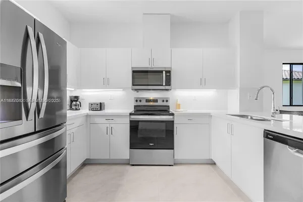 a kitchen with cabinets stainless steel appliances and a sink