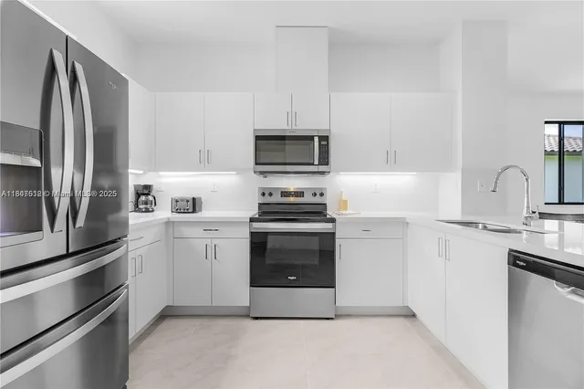 a kitchen with cabinets stainless steel appliances and a sink