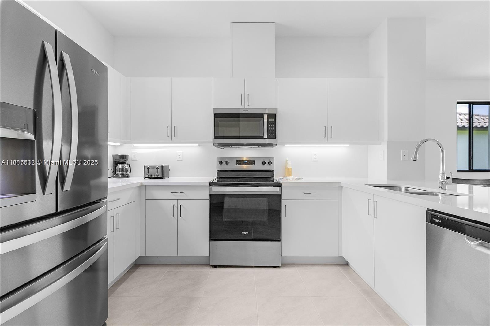 5061 Panella Avenue Immokalee, FL 34142 - Photo 7 of 13 a kitchen with cabinets stainless steel appliances and a sink