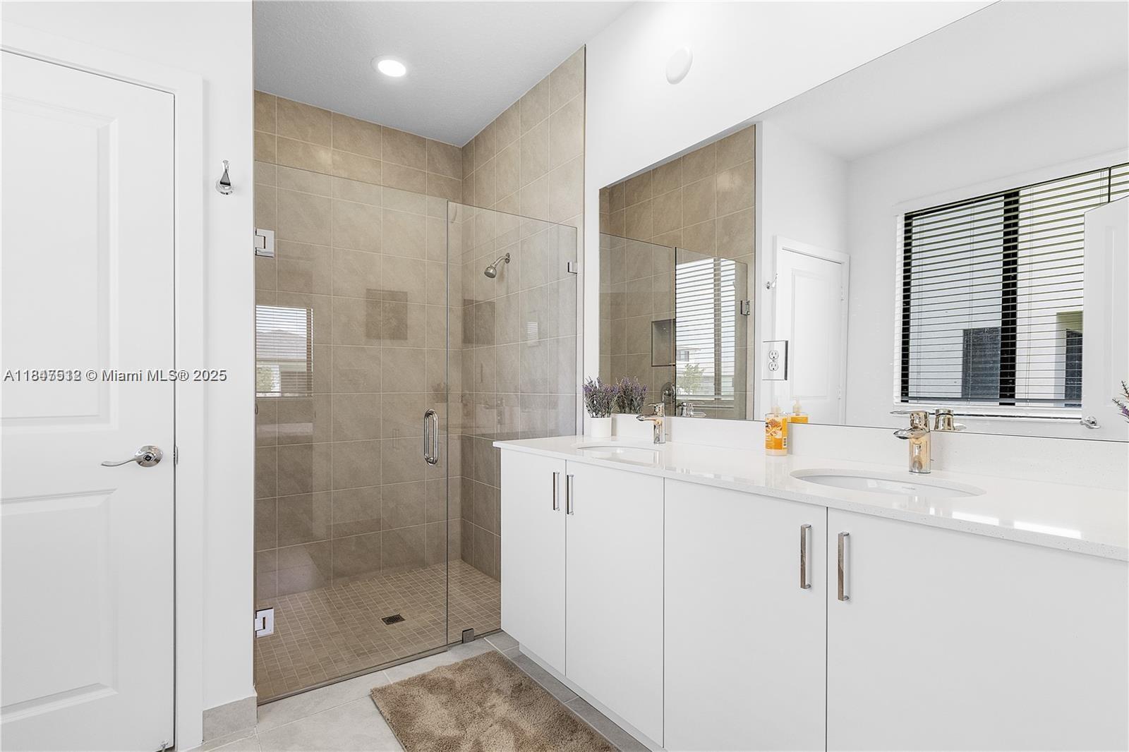 5061 Panella Avenue Immokalee, FL 34142 - Photo 9 of 13 a bathroom with a double vanity sink mirror and shower