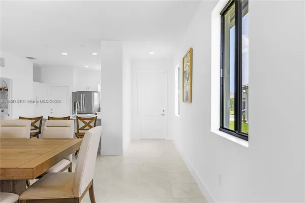 a dining room with stainless steel appliances furniture a window and a kitchen view