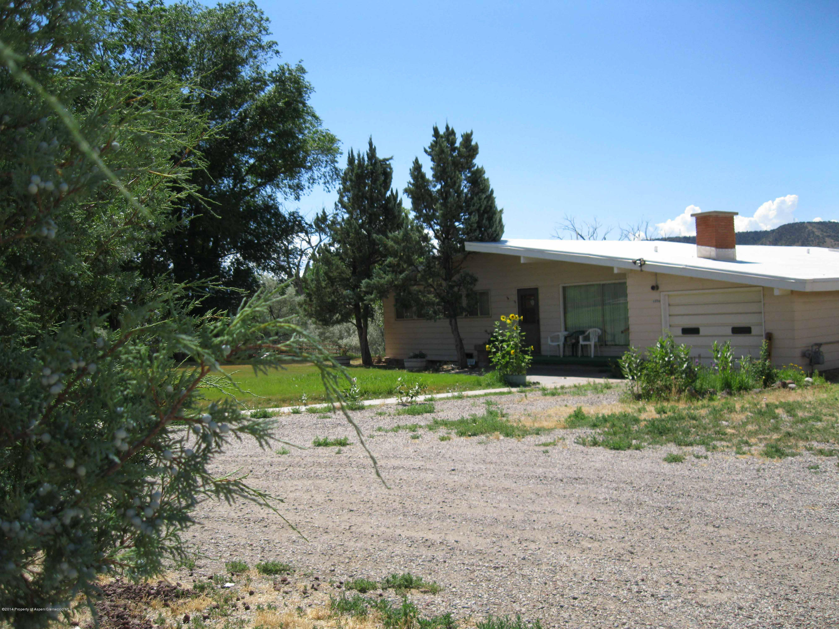 506 County Road 294 Rifle, CO 81650 - Photo 2 of 23 a front view of house with a yard and trees all around