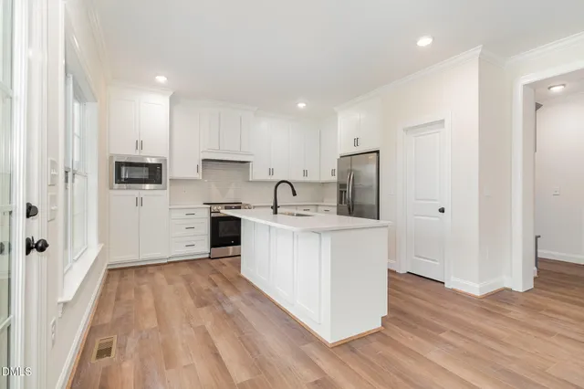 a kitchen with white cabinets and stainless steel appliances