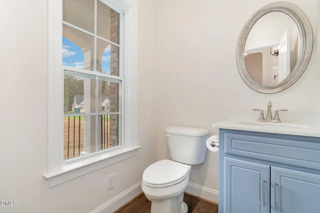 a bathroom with a toilet a sink and a mirror