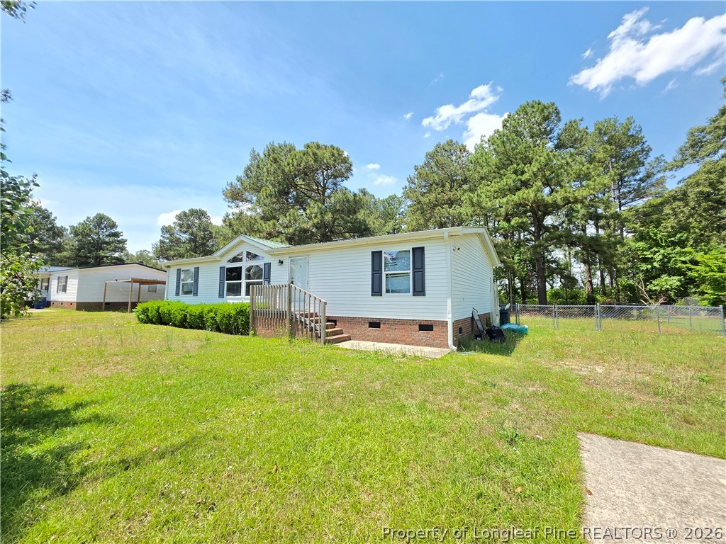 124 Franklin Road Raeford, NC 28376 - Photo 2 of 15 a front view of house with yard and trees in the background