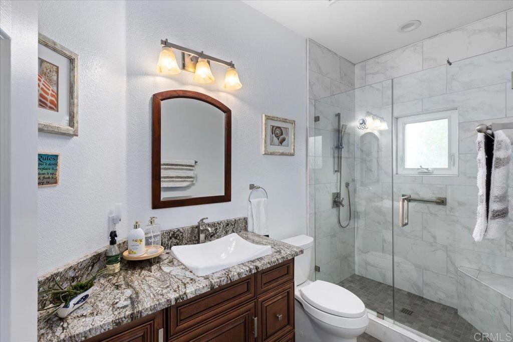 1838 Samoa Way Oceanside, CA 92054 - Photo 12 of 49 a bathroom with a granite countertop toilet sink and mirror