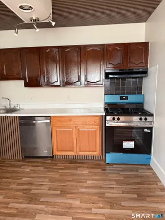a kitchen with stainless steel appliances wooden cabinets and a stove top oven