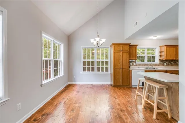a view of a kitchen with granite countertop wooden floor and stainless steel appliances