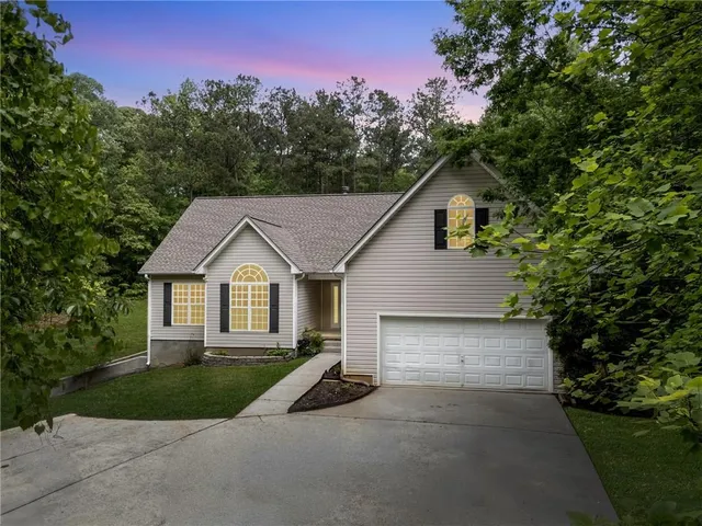 a view of a house with a yard and large tree