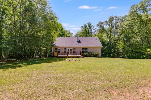 a aerial view of a house with swimming pool and large trees