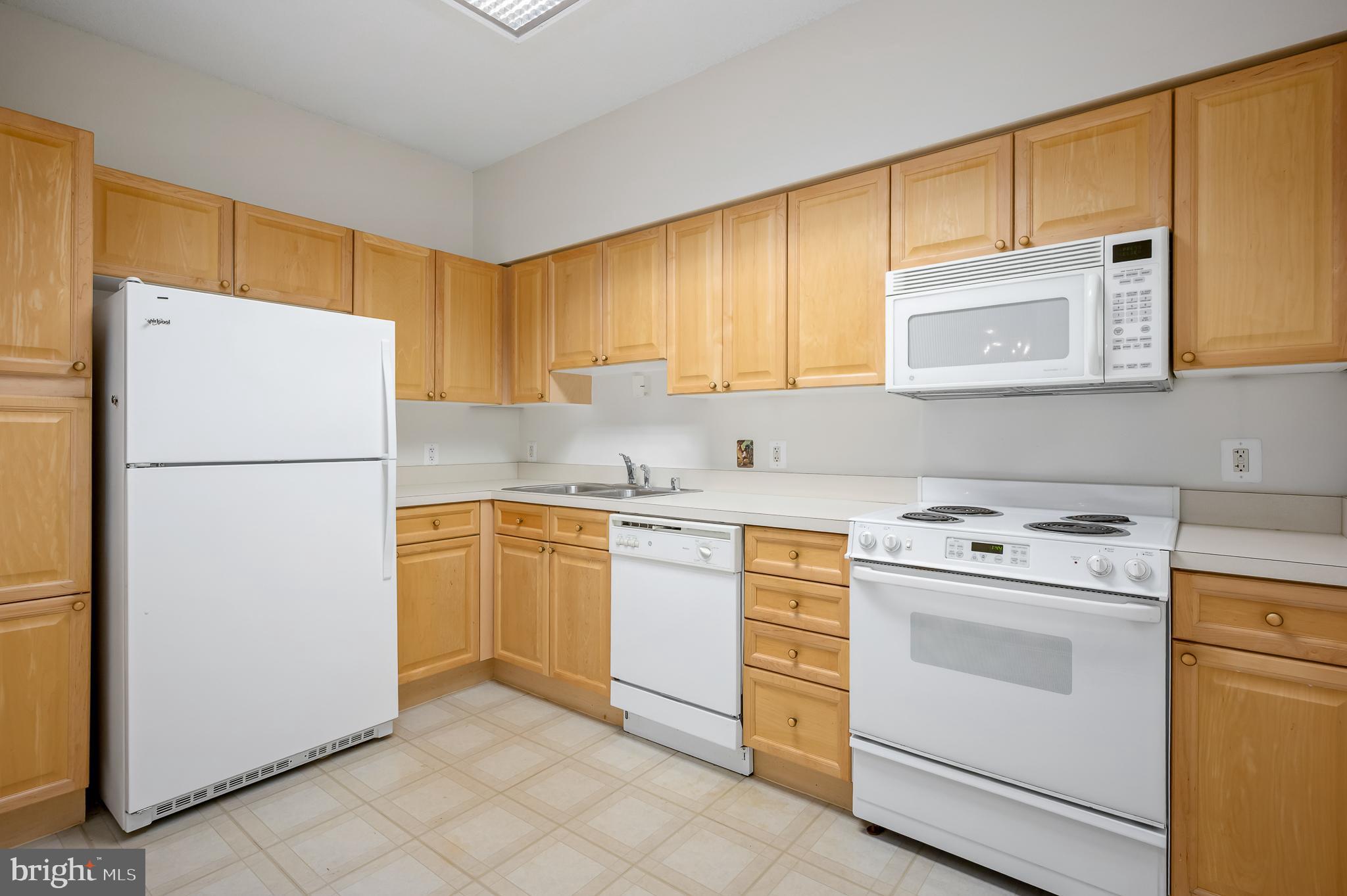 19365 Cypress Ridge Terrace, Unit 519 Leesburg, VA 20176 - Photo 8 of 24 a kitchen with a refrigerator sink stove and cabinets