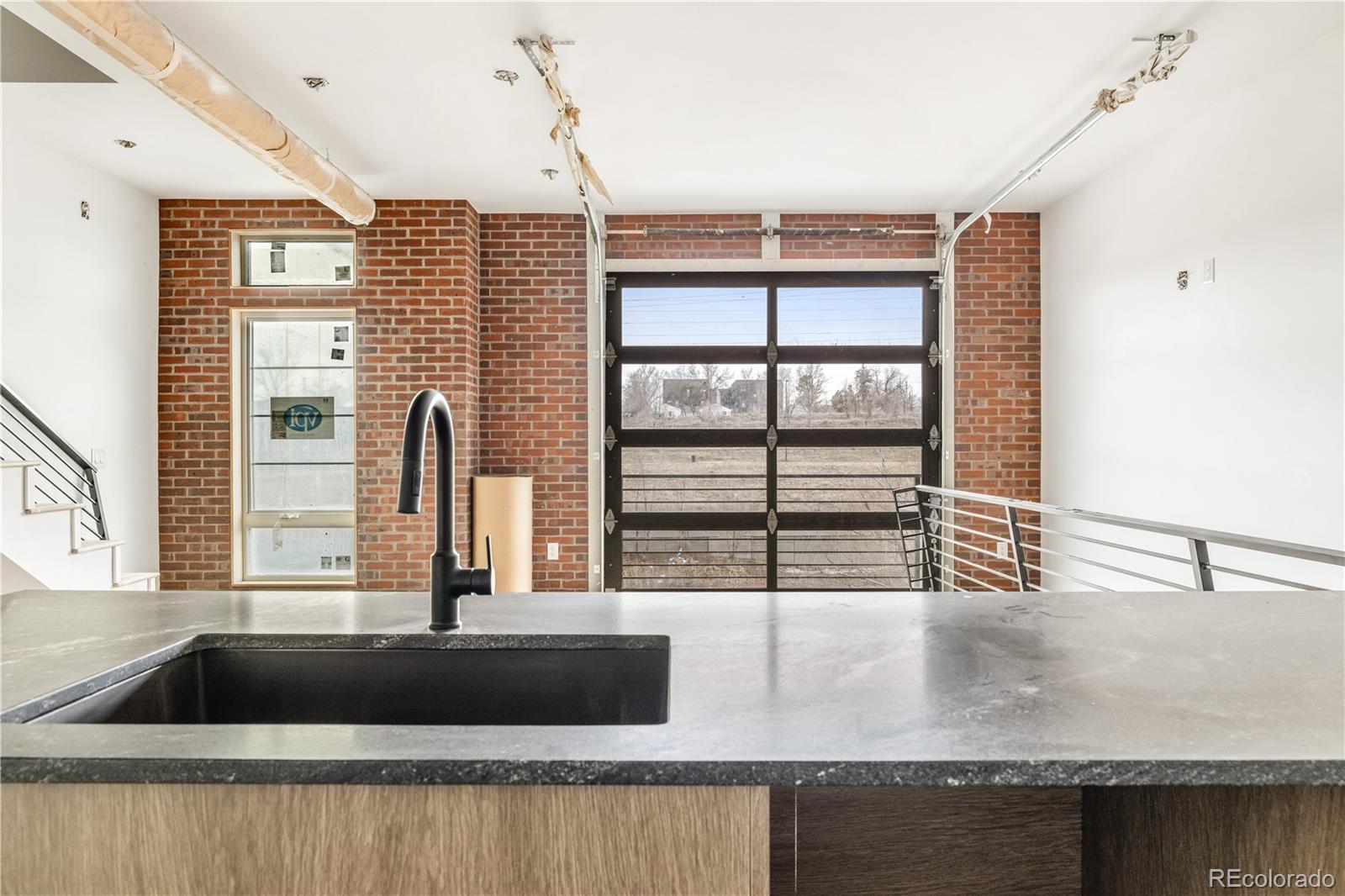 a kitchen with a granite countertop sink and large window