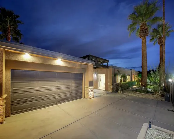 a view of a patio with table and chairs under an umbrella