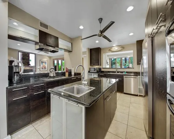 a kitchen with stainless steel appliances granite countertop a sink stove and refrigerator