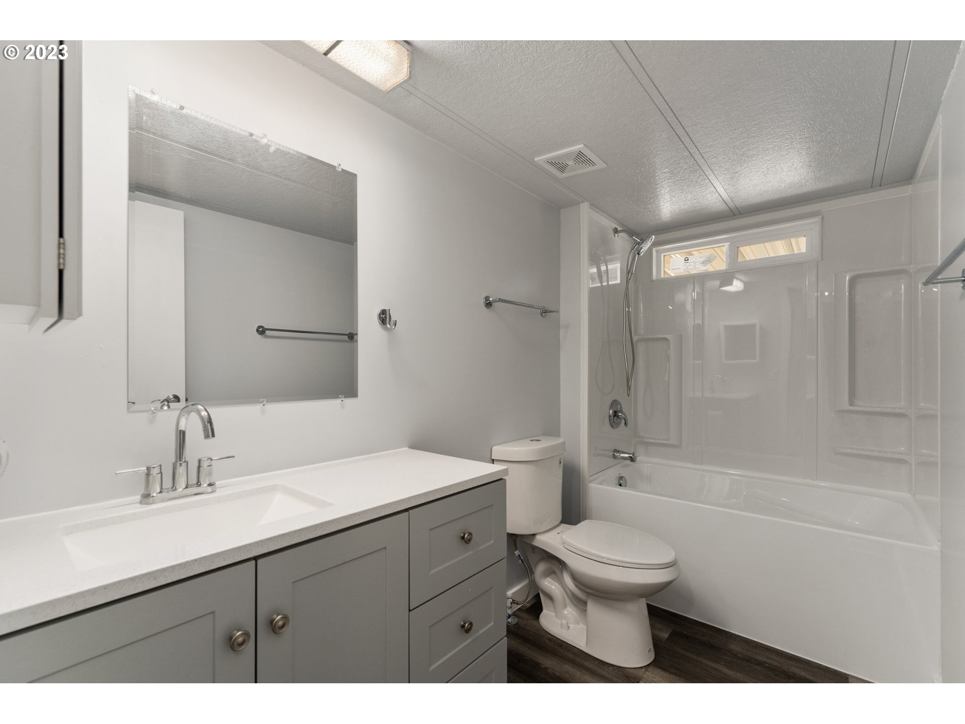 3130 U Street Springfield, OR 97477 - Photo 16 of 28 a bathroom with a toilet a sink a mirror and a bathtub