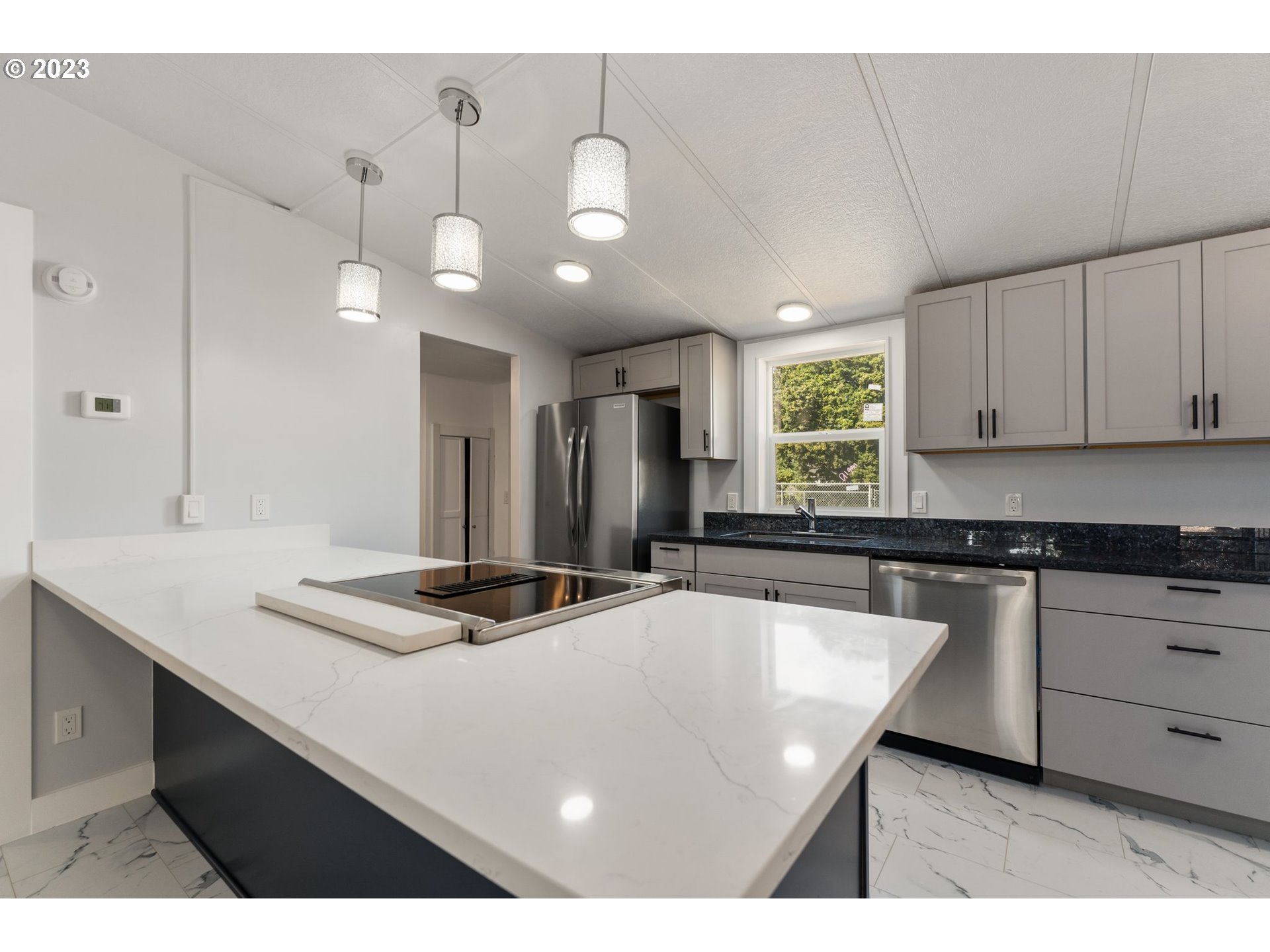 3130 U Street Springfield, OR 97477 - Photo 7 of 28 a kitchen with kitchen island granite countertop a sink cabinets and window