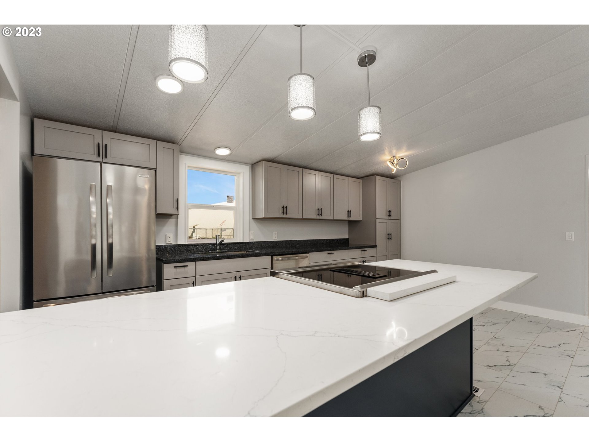 3130 U Street Springfield, OR 97477 - Photo 9 of 28 a kitchen with kitchen island a sink stainless steel appliances and cabinets