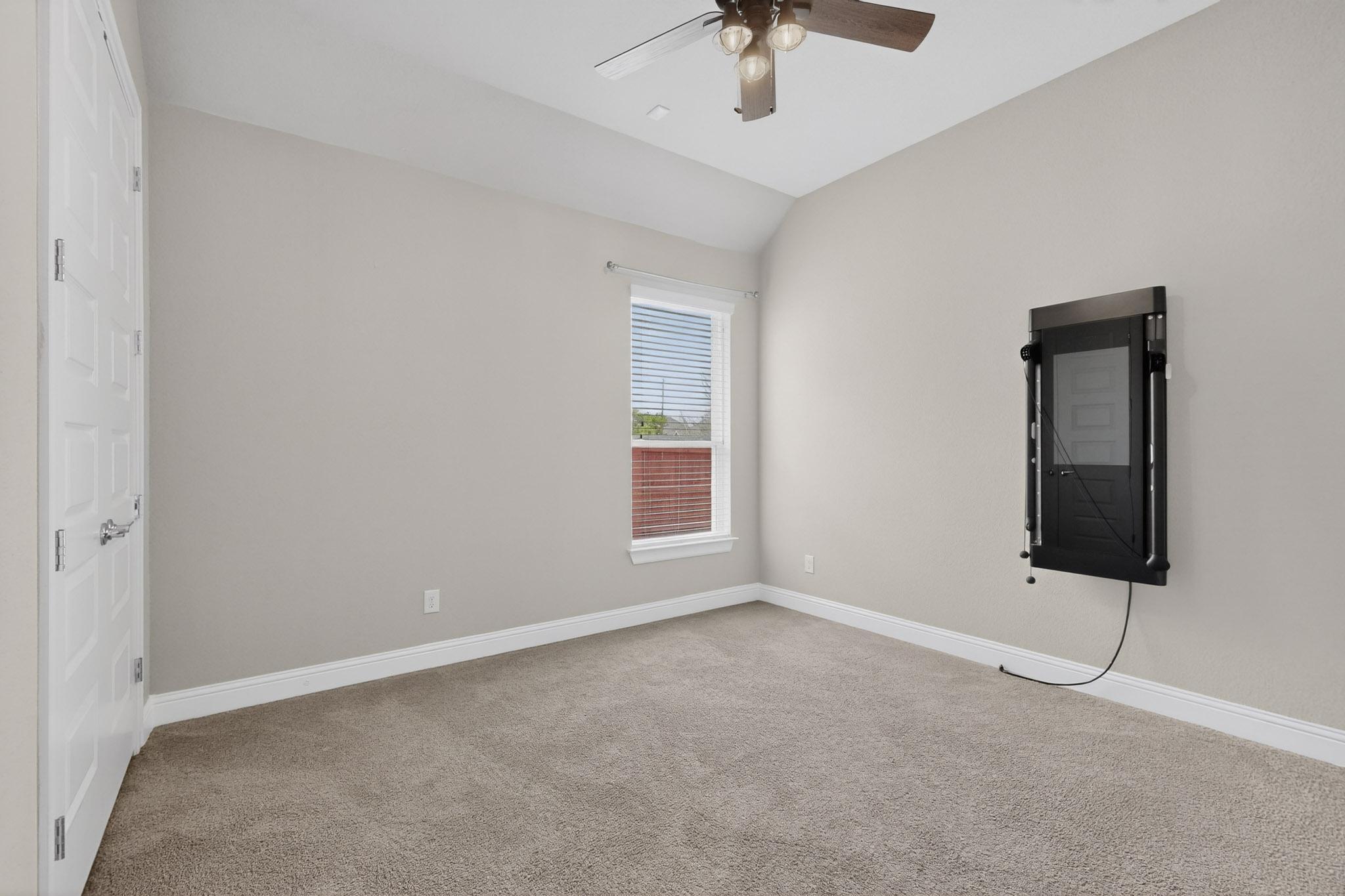 3137 Catalina Ranch Road Leander, TX 78641 - Photo 10 of 21 Empty room featuring lofted ceiling, light colored carpet, and a ceiling fan
