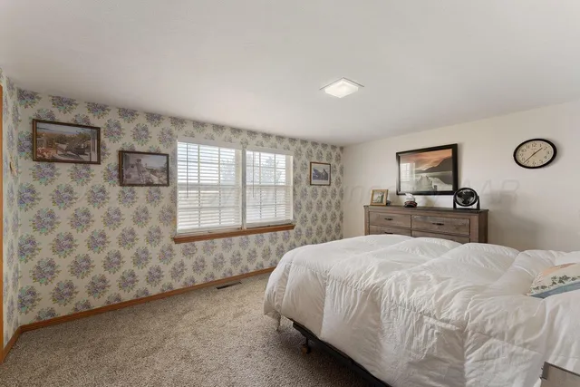 a spacious bedroom with a bed and a flat screen tv