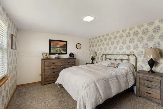 a bedroom with a bed and a flat tv screen on dresser