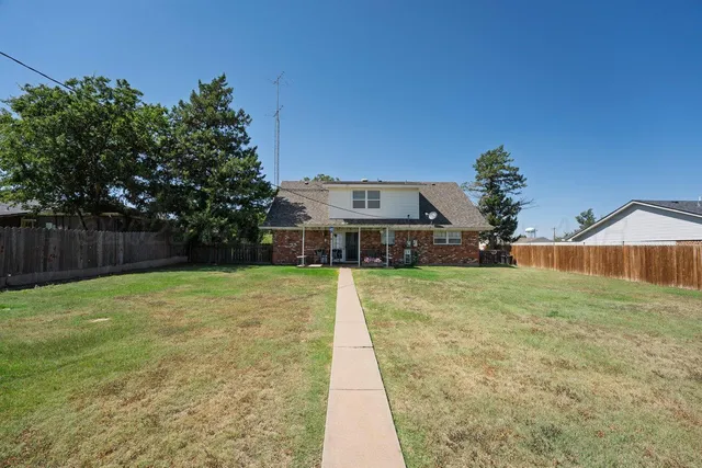 a front view of a house with a yard and trees