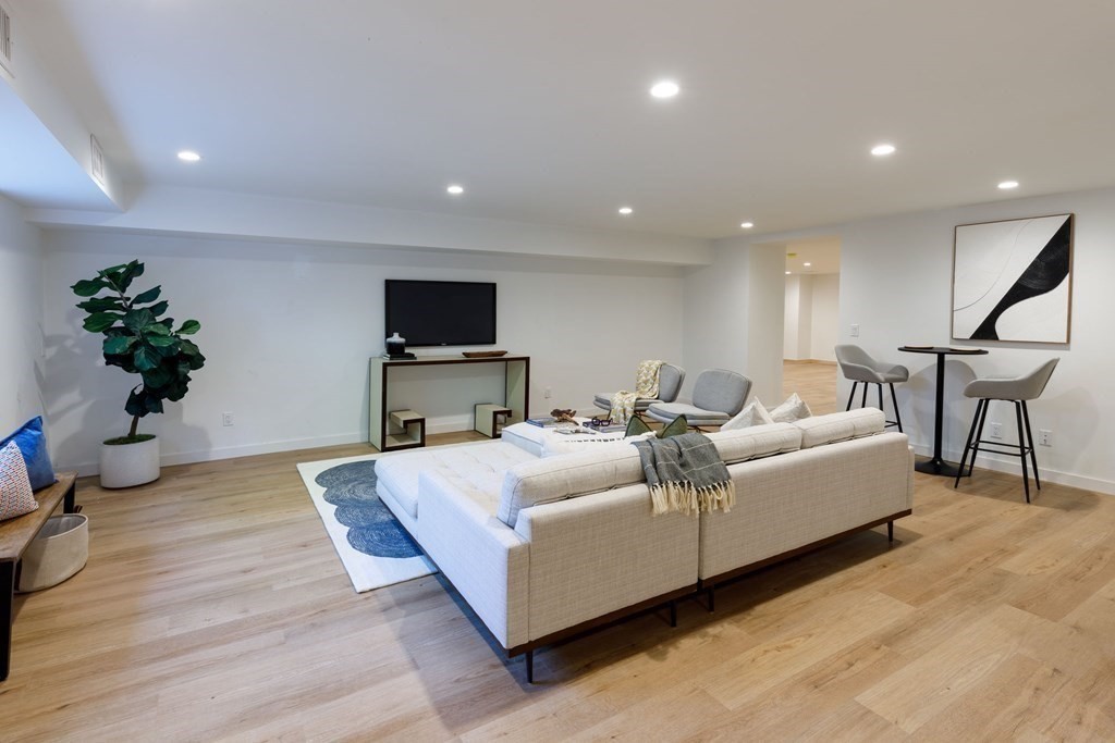 43 Ruane Road Newton, MA 02465 - Photo 19 of 24 a living room with furniture a potted plant and a flat screen tv